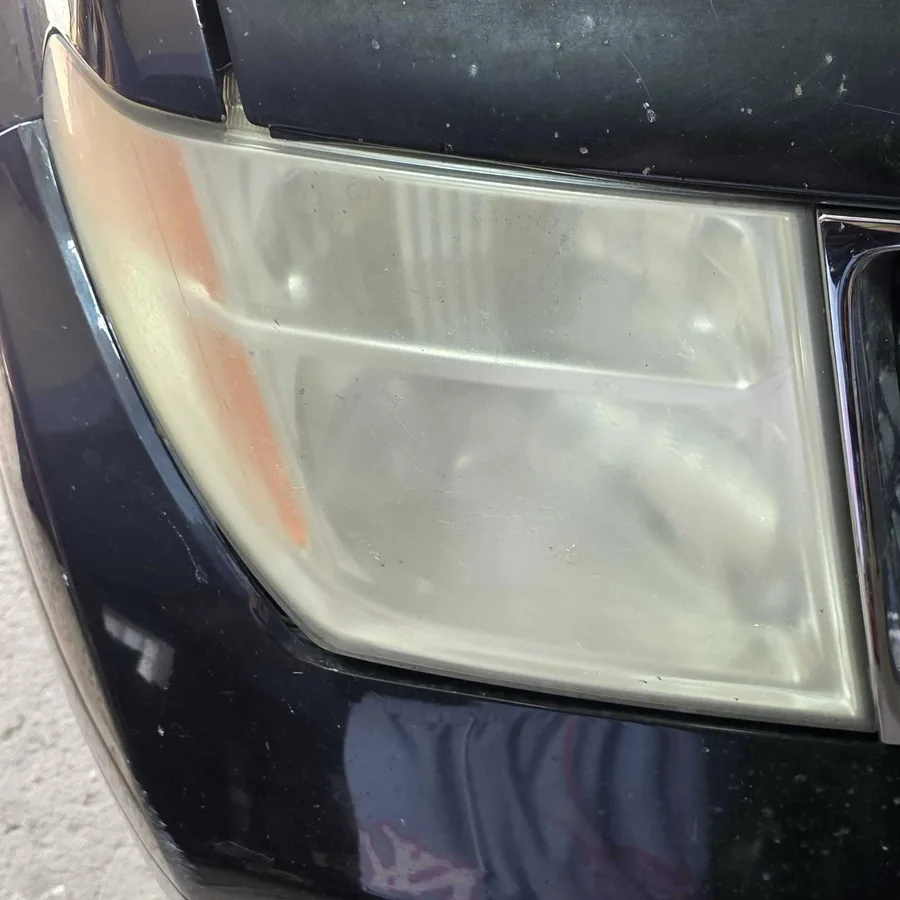 Close up of cloudy oxidized headlight lens before restoration