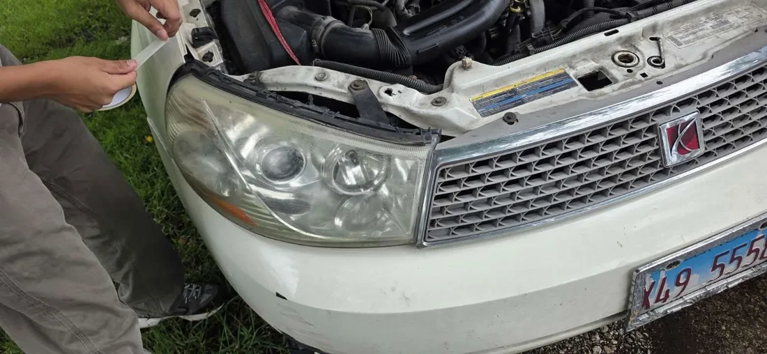 Technician masking headlight before sanding