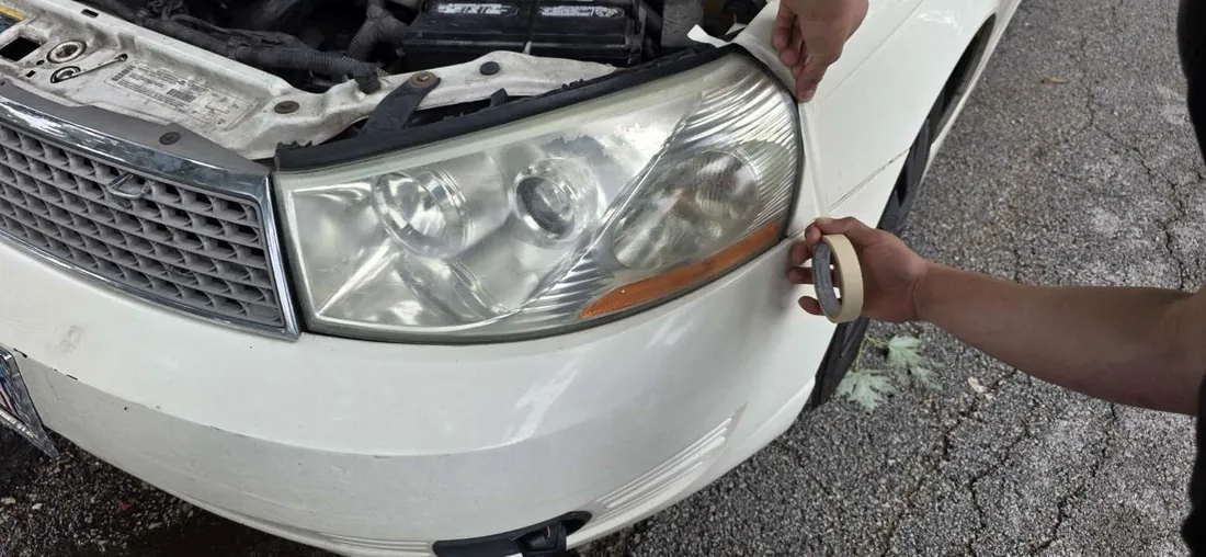 Taping around headlight before restoration